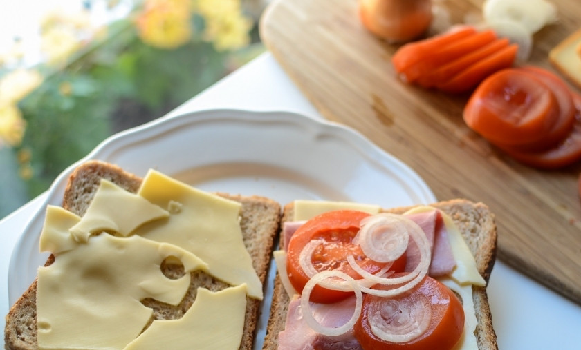 1. Этап. Тосты в бутерброднице: Сверху каждого ломтика хлеба для тостов положите кусочек сыра. На один из пары ломтиков хлеба положите кусочек ветчины, кружочки помидора и колечки лука.