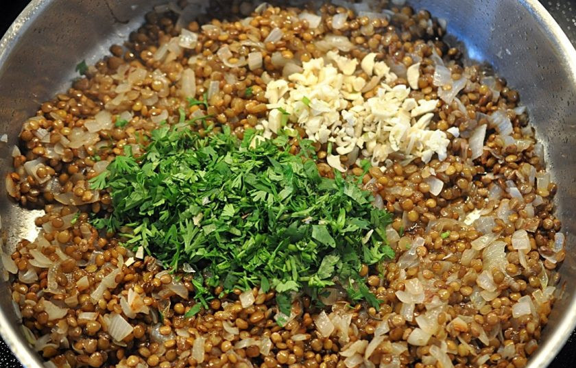 1. Этап. Каре баранины: В чечевицу и обжаренный лук добавьте кинзу, а также немножко измельченного чеснока.