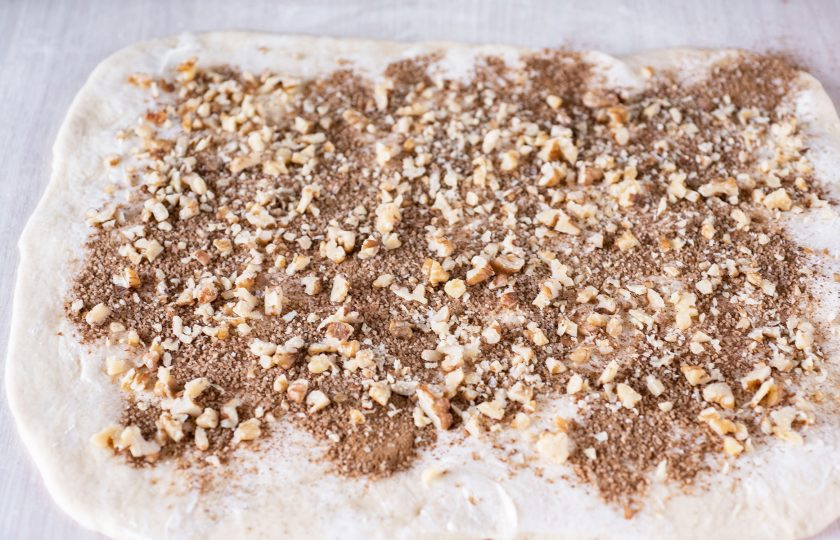 1. Этап. Булочки с грецкими орехами и корицей: Сначала распределите по поверхности пласта теста смесь сахара и корицы (40 грамм сахара смешайте с 2 ч.л. корицы в отдельной мисочке), а затем равномерно присыпьте рублеными грецкими орехами.