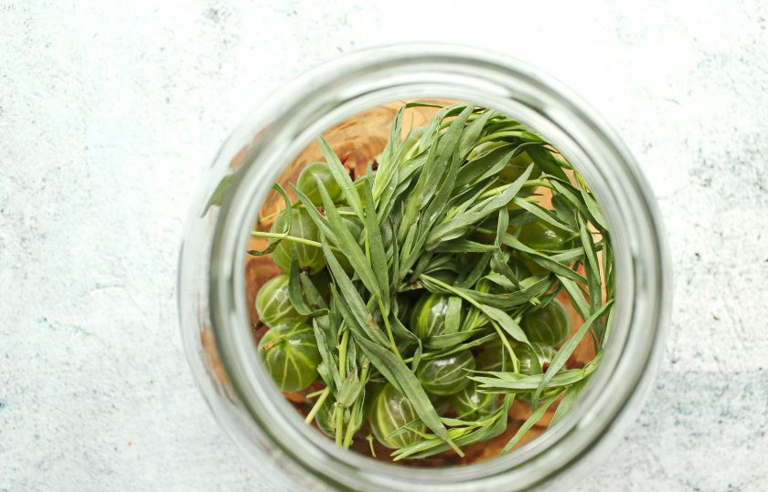 1. Этап. Компот Тархун из крыжовника на зиму: Добавьте к ягодам веточки тархуна.