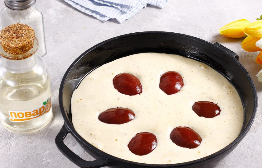 1. Этап. ПП пирог со сливами: Смажьте форму растительным маслом и выложите в нее тесто. Разогрейте духовку до 180 градусов. В тесто выложите половинки слив и отправьте форму в духовку.