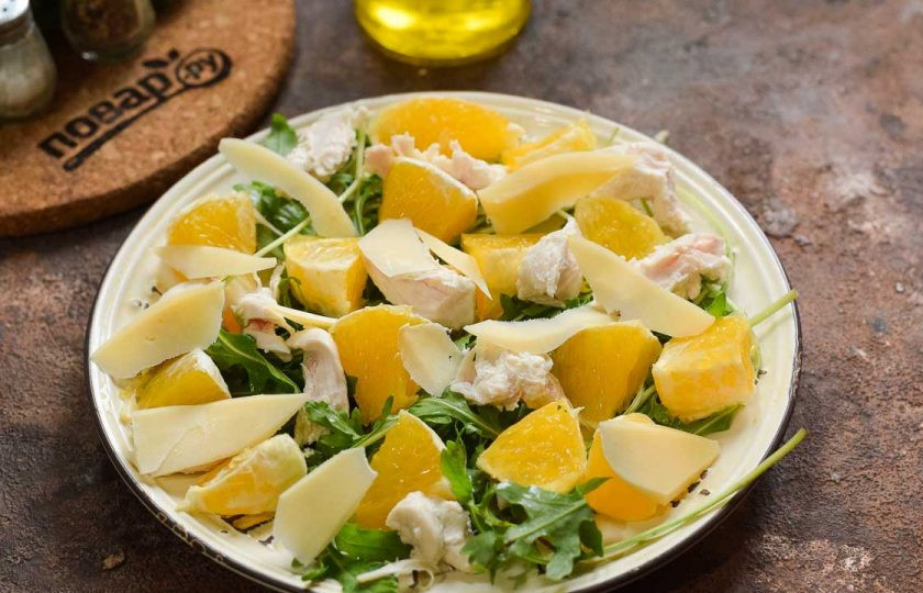 1. Этап. Салат из курицы с рукколой и апельсинами: Сбрызните салат маслом и добавьте нарезанный пластинами сыр. Соль и перец всыпьте по вкусу. Салат подавайте к столу.