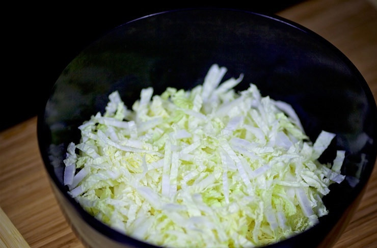 1. Этап. Салат с отварной курицей, яйцом и овощами: 2. Нашинкуйте капусту, выложите её в глубокий салатник.