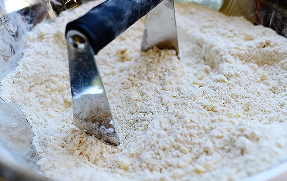 1. Этап. Песочные сконы с сыром и перцем: 2. Добавьте кубики сливочного масла и перемешайте тесто, оно будет иметь рассыпчатый вид.