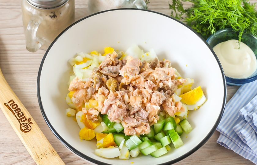 1. Этап. Салат с консервированной горбушей и яйцами: Вскройте консервы и слейте масло, выложите мякоть горбуши в емкость и слегка разомните вилкой.