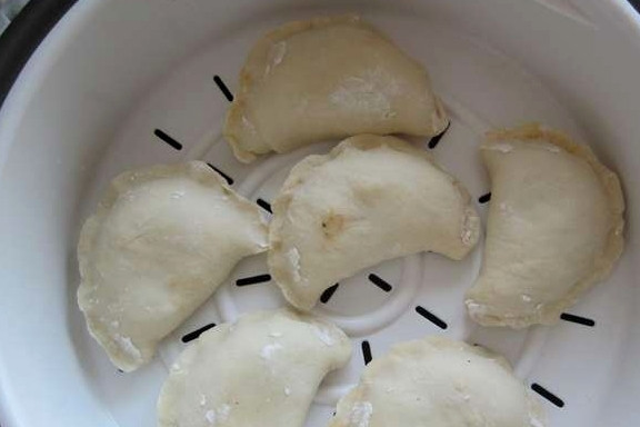 1. Этап. Вареники с капустой на пару: Я готовила вареники в мультиварке, но вы можете сделать это и в пароварке. Итак, наливаем в чашу немного воды, устанавливаем форму для варки на пару и выкладываем на нее вареники. Закрываем крышку мультиварки, выбираем режим 