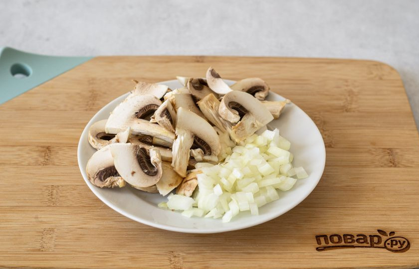 1. Этап. Рисовая каша с грибами: Очистите лук, нарежьте кубиками. Шампиньоны помойте, нарежьте крупными ломтиками.