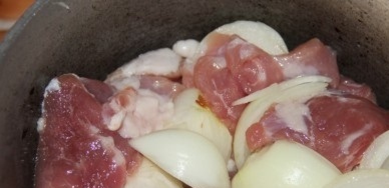 1. Этап. Мясо в сливочном соусе: Переложите мясо и лук в казан. Посолите и поперчите.