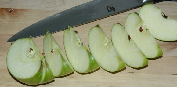 1. Этап. Запеченные яблоки с корицей: Нарежьте яблоко на 8 долек. Сделайте это, разрезая яблоко от одного полюса к другому и повторяйте с половинки к четверти.