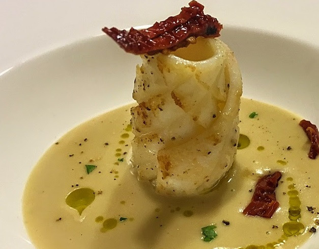 1. Этап. Кальмары в сметане: 3. В сотейнике на масле обжарьте в течение 3-4 минут очищенный зубчик чеснока и веточку розмарина, чтобы специи отдали свой вкус маслу. Выберите и выложите консервированный нут. Прогрейте нут минут 5, помешивая, затем добавьте сметану, посолите и тушите на медленном огне еще минут 5. Затем взбейте соус блендером. Выложите на тарелку пару ложек соуса, в центр - кусочек кальмара (или несколько) и украсьте кусочками вяленых на солнце помидоров с маслом и черным перцем. Приятного аппетита!