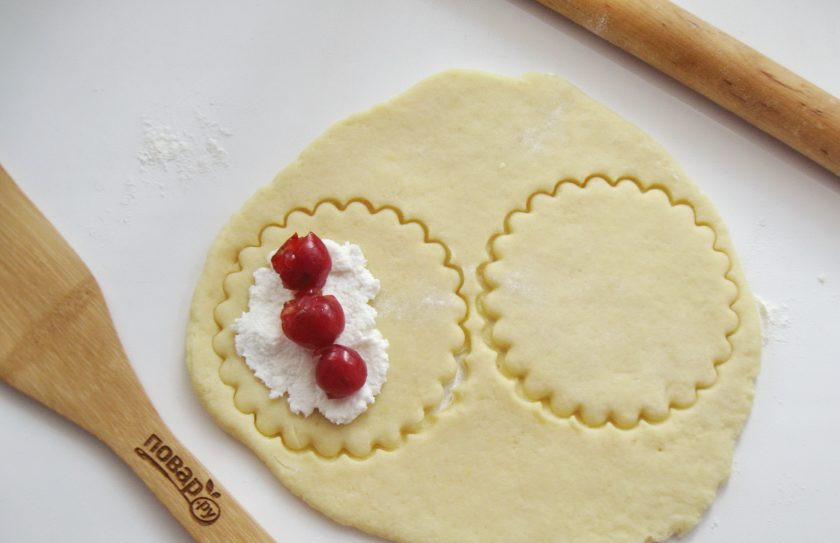1. Этап. Сочники с вишней: На каждый кружок выложите творог и вишню.