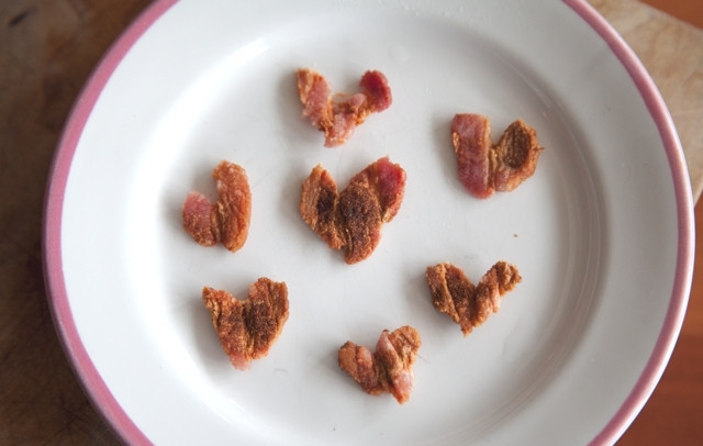 1. Этап. Салат Признание: Сложите по две полосочки бекона в форме сердца и слегка прижмите пальцем. Присыпьте паприкой.