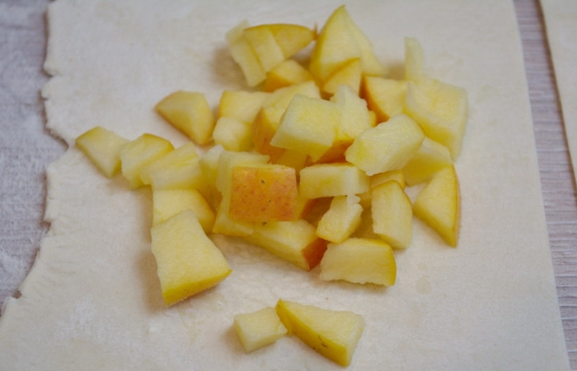 1. Этап. Конвертики из слоеного бездрожжевого теста: Яблочную мякоть нарежьте кубиками. Тесто нарежьте на квадраты.