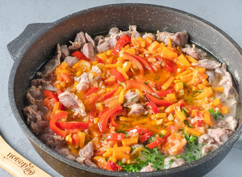 1. Этап. Куриные желудки с овощами: По истечении времени добавьте овощи к желудкам, перемешайте и тушите на медленном огне под крышкой ещё 10-12 минут. При необходимости ещё немного посолите.