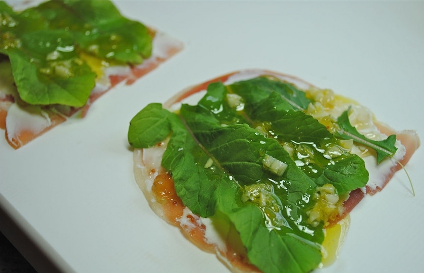 1. Этап. Рулетики из ветчины с сыром: Теперь поверх кладем листья рукколы, сбрызгиваем полученной смесью из масла и лимонного сока, приправляем по вкусу черным молотым перцем.