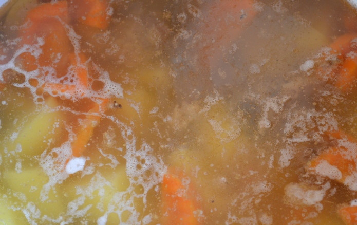 1. Этап. Соус из говядины с картошкой: После того как пройдет час с момента закипания бульона, мы аккуратно извлекаем из него луковицу и лавровый лист (они нам больше не понадобятся). Опускаем нарезанные свежие овощи в воду, доводим ее до кипения, затем солим по вкусу. Варим суп еще 35-40 минут, а за 5 минут до готовности добавляем в него сушеную зелень.