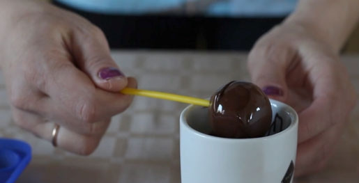 1. Этап. Попкейк: 8. Теперь окунаем каждый попкейк в шоколад и хорошо проворачиваем трубочку, чтобы глазурь равномерно распределилась по всей поверхности.