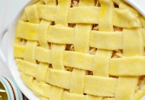 1. Этап. Именинный пирог: Раскатайте вторую часть теста, нарежьте ее на полоски и выложите их крест накрест поверх начинки. Смажьте тесто яичным желтком и посыпьте сахаром.