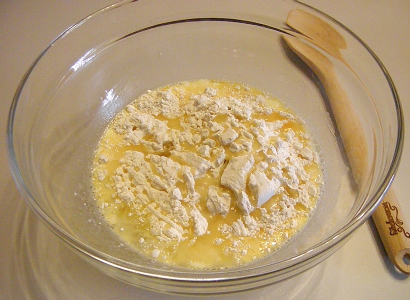 1. Этап. Заварные блины на молоке: Всыпьте муку, влейте растительное масло. Венчиком размешайте всё, чтобы тесто стало однородным.