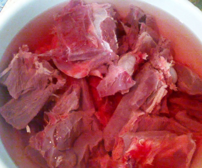 1. Этап. Жаркое из косули: Ногу косули разделайте на порционный куски, помойте. Уложите в миску и залейте водой. Добавьте уксус. Оставьте её мариноваться на 3 часа.