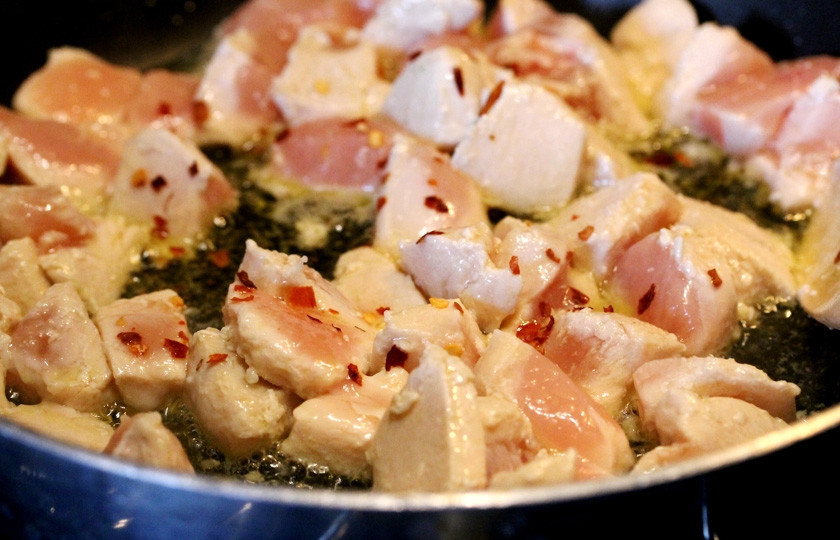 1. Этап. Курица по-японски: Прожарьте с каждой стороны и добавьте специи (молотый красный и чёрный перец).