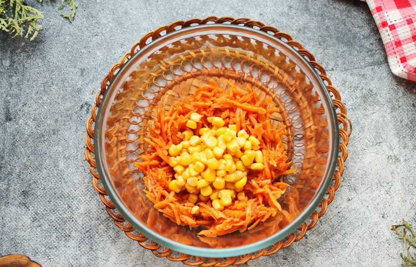 1. Этап. Салат с сыром, кукурузой и морковью: Морковь по-корейски и кукурузу выложите в салатник.