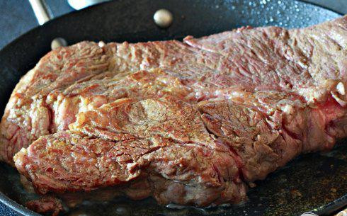 1. Этап. Говядина с кукурузными лепешками: 1. Нагреть большую сковороду на среднем огне, добавить оливковое масло и немного соуса адобо. Обжарить мясо около 5 минут с каждой стороны, пока оно равномерно не подрумянится.