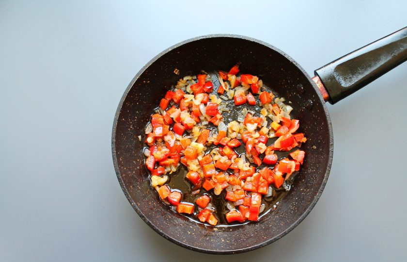 1. Этап. Голубцы в стеблях лука порея: В сковороду налейте растительное масло и выложите мелко нарезанный репчатый лук и болгарский перец. Обжаривайте овощи на среднем огне в течение 5 минут, остудите.