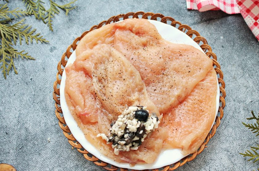 1. Этап. Куриные рулетики с грибами, маслинами и сыром: Добавьте в сырную массу обжаренные грибы с луком и перемешайте. Разложите начинку на отбитое филе с одной стороны.
