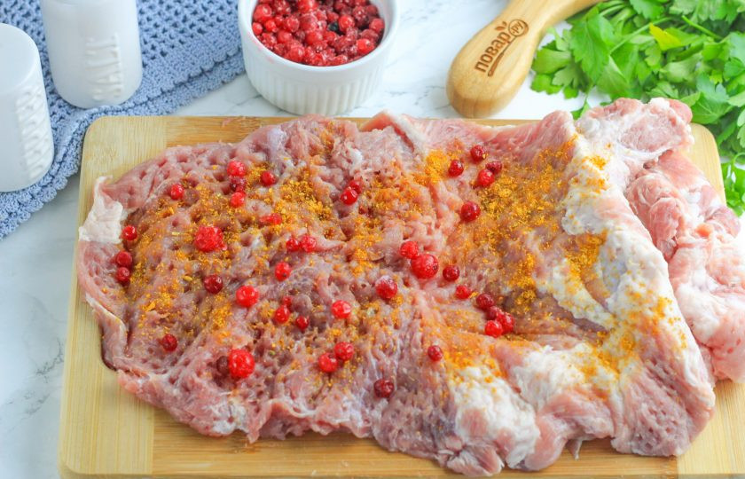 1. Этап. Мясной рулет с брусникой в духовке: Выложите промытые ягоды брусники хаотично на мясо.