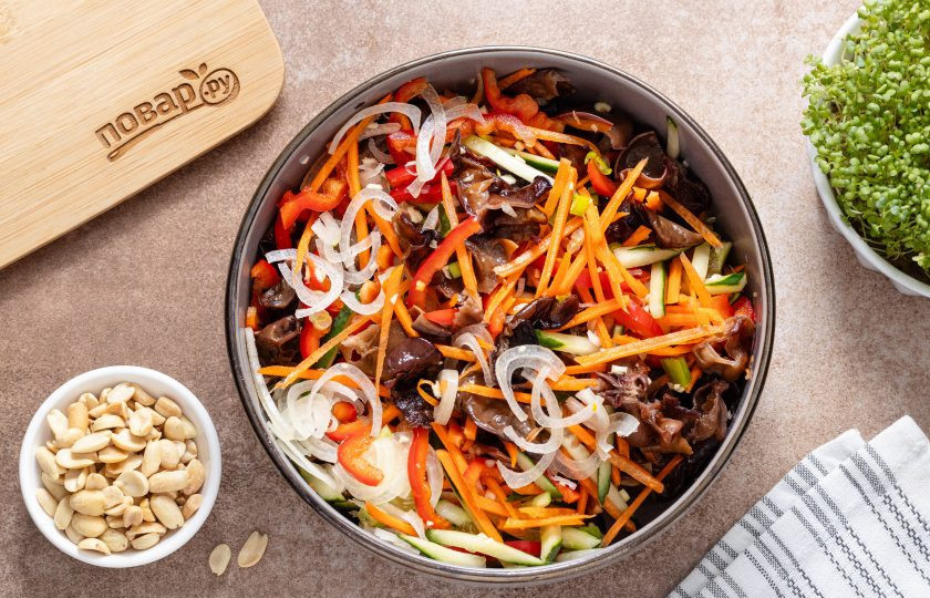 1. Этап. Закуска с древесными грибами и арахисом: Соедините в глубокой миске нарезанные грибы и овощи.