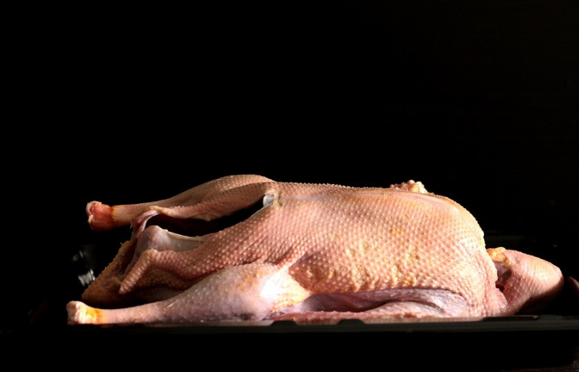 1. Этап. Гусь с рисом в духовке: Кожу отделите (но будьте аккуратны и не порвите её) от передней и задней части гуся, дойдя до ножек.