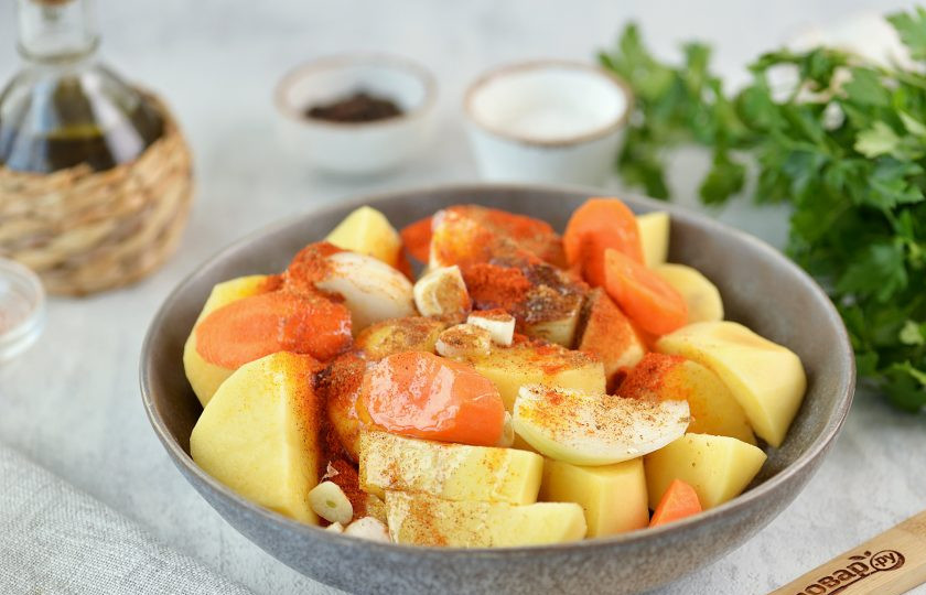 1. Этап. Телячья ножка с овощами в духовке: Добавьте нарезанную морковь, специи и приправы, тщательно все перемешайте.