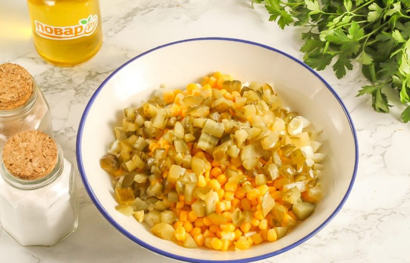 1. Этап. Салат с тунцом и кукурузой в тарталетках: Нарежьте соленые огурцы мелкими кубиками и оставьте нарезку на 5 минут, чтобы из нее выделился рассол. Затем тоже слегка отожмите и добавьте в емкость.