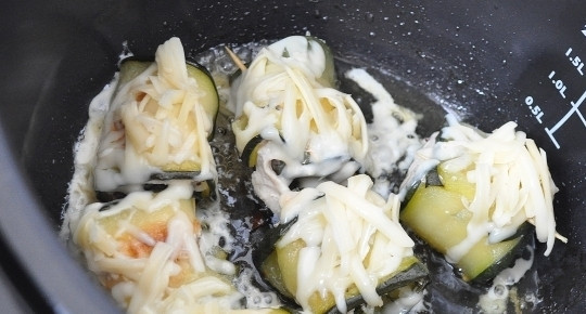 1. Этап. Нежные рулетики из кабачков с куриным филе: За пять минут до готовности откройте мультиварку и посыпьте рулетики заренее натертым на крупную терку твердым сыром.