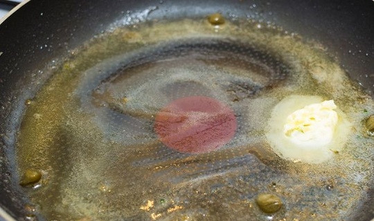 1. Этап. Кальмары с брокколи: 8. На отдельную сковороду выложите сливочное масло, каперсы и немного сока лимона. Поставьте на средний огонь, пока масло не растает.