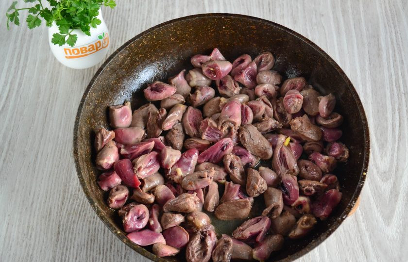 1. Этап. Куриные сердечки с макаронами: Сердечки промойте, удалите жилки и жирок. Разрежьте сердечки пополам. В сковороде разогрейте растительное масло, выложите сердечки и обжаривайте их до испарения жидкости.