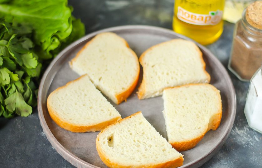 1. Этап. Бутерброды с печенью трески и творожным сыром: Хлебные ломтики разрежьте пополам и выложите на тарелку. Можно использовать любой сорт хлеба по вашему вкусу.