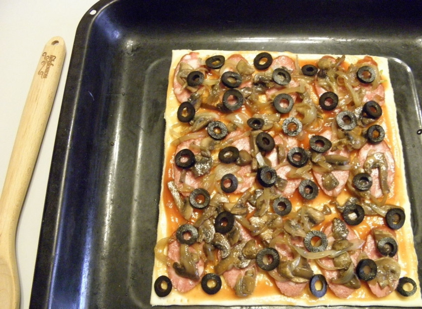 1. Этап. Пицца из слоеного теста в духовке: Разложите колечки оливок.