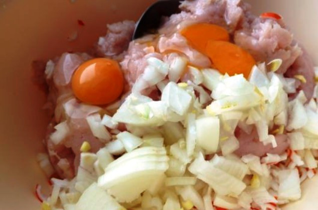 1. Этап. Котлеты куриные с крабовыми палочками: Добавьте яйца, измельченный лук, размоченный в молоке хлеб, соль и специи по вкусу. Хорошо перемешайте.