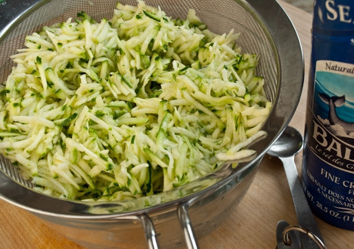 1. Этап. Драники с сыром и зеленым луком: 2. Выложите кабачки в сито и посолите, оставьте на 10 минут, а затем отожмите кабачки руками от лишней жидкости.