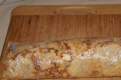 1. Этап. Рулеты из блинов с семгой: А вот теперь позовите на помощь кого-нибудь из домочадцев, чтобы они помогли вам свернуть рулет. Если никого нет дома - пробуйте сделать это самостоятельно. Плотно сворачиваем рулет и заворачиваем его в пленку. Отправляем в холодильник на 2-3 часа.