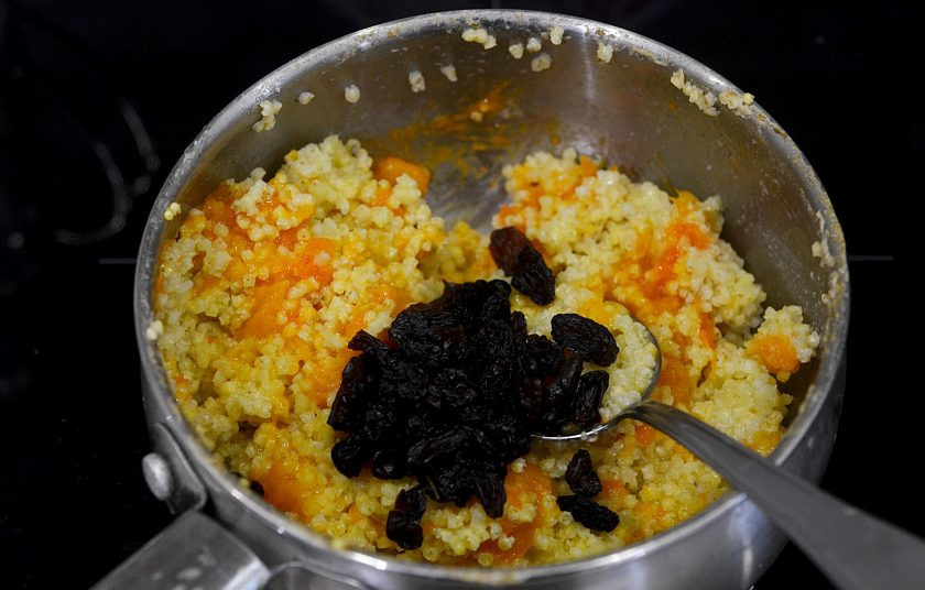 1. Этап. Тыквенная каша с изюмом: Влейте масло, добавьте промытый и ошпаренный изюм.