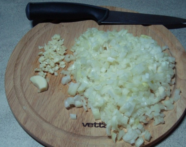 1. Этап. Пирожки с куриным фаршем: Теперь займемся начинкой: измельчаем репчатый лук и чеснок.