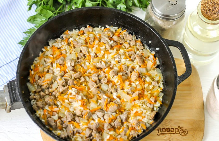 1. Этап. Долма из перцев: Влейте 0,5 стакана горячей воды и отварите рис в мясном бульоне до полуготовности. Посолите начинку и выключите нагрев. Дайте ей слегка остыть.