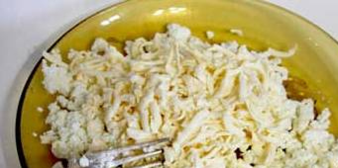 1. Этап. Лаваш с творогом: 2. Натрите на крупной терке сыр и затем смешайте его с творогом. Разомните тщательно полученную массу. Я это делаю вилкой – так быстрее и удобнее. Добавьте измельченный чеснок, но это по желанию, хотя классический рецепт лаваша с творогом включает в себя чеснок.