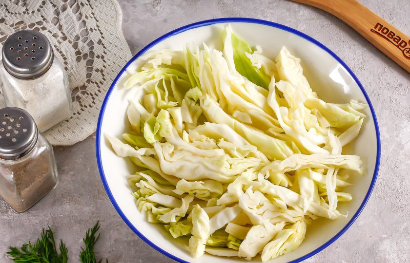 1. Этап. Запеченный карп в духовке с капустой: Капусту нарежьте крупными ломтиками, лентами, но не мелко, иначе она при запекании она превратится в пюре. Посолите и поперчите, сбрызните растительным маслом.