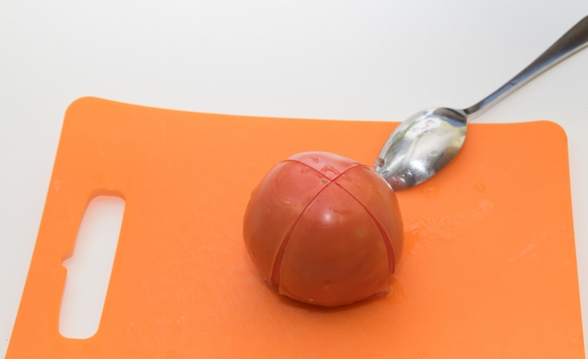 1. Этап. Жареные кальмары с овощами: Очистим с помидора кожицу, для этого опустим его сначала в кипяток, а затем в холодную воду. Нарежем небольшими кусочками.