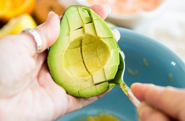 1. Этап. Салат с сёмгой: Разрежьте авокадо на две половины. Плод должен быть спелым и мягким. Удалите косточку, достаньте мякоть и нарежьте её кубиками.