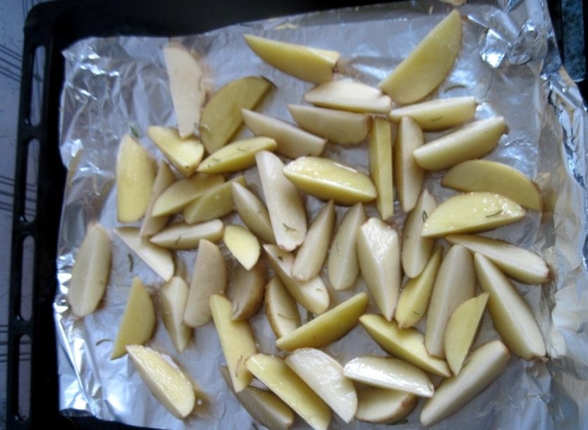 1. Этап. Молодой картофель в фольге: Противень застилаем фольгой и на нее выкладываем приправленные дольки и сверху сбрызгиваем оливковым маслом.